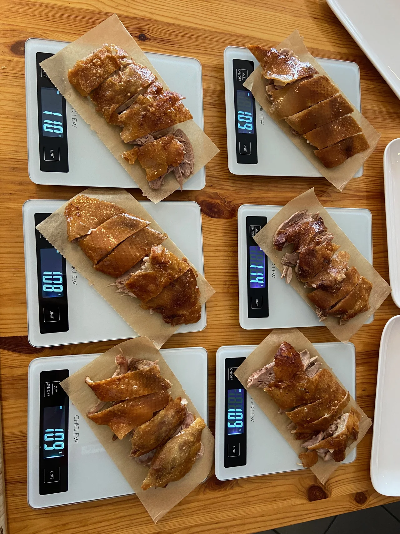 Sechs Waagen mit fertig tranchierter Pekingente — Gewichte zwischen 88 und 169 Gramm